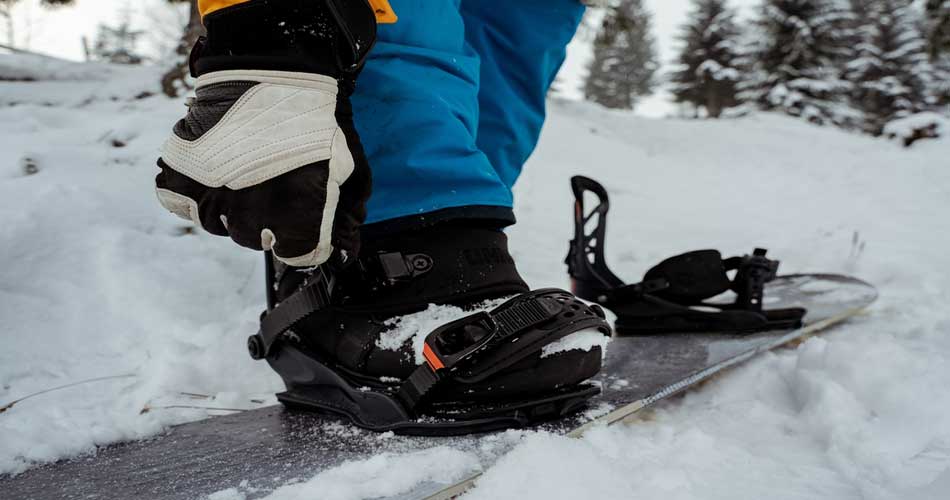 Strapping into snowboard at Herman Mountain.