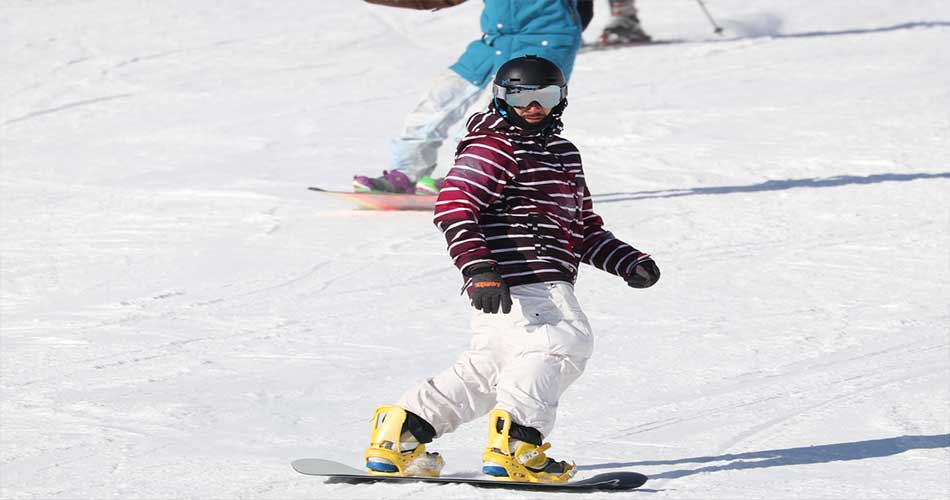 Guy snowboarding at Cranmore Mountain Resort.