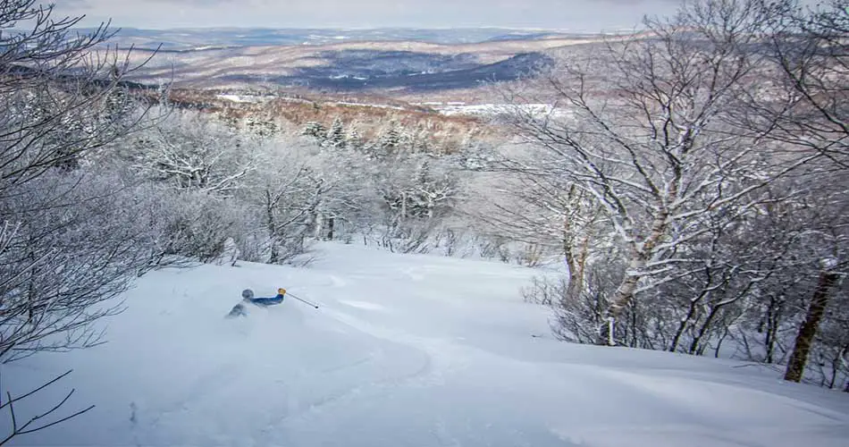 Skiing deep snow at Bolton Valley Ski Resort.