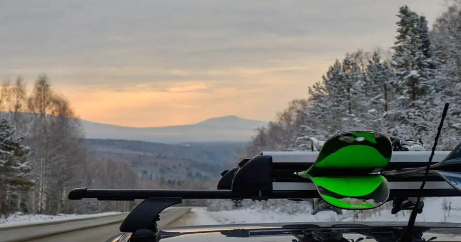 Skis on vehicle rack going to ski resort.