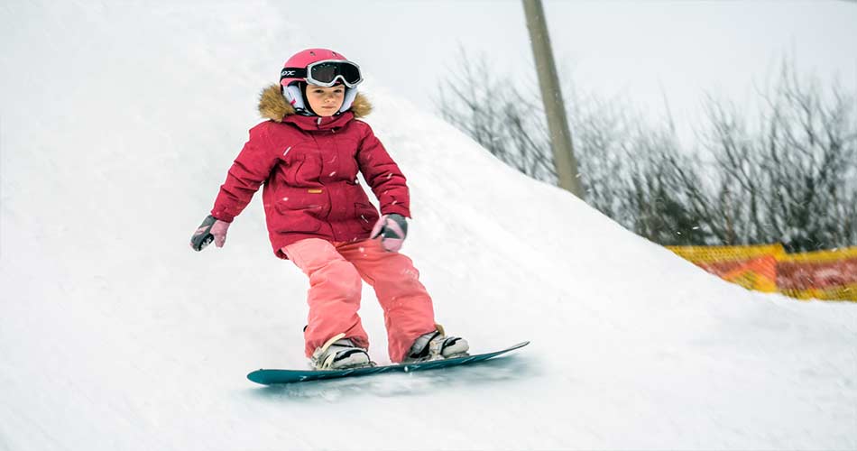 Girl taking snowboard lessons with rental gear.
