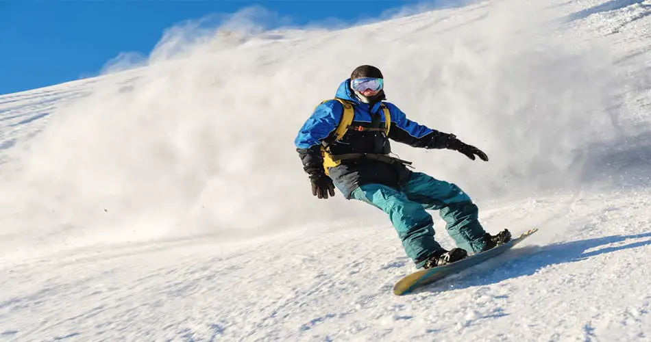 Advanced snowboarder snowing deep heelside turn.