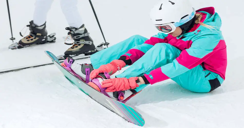 Snowboarder putting on bindings at Shawnee Mountain in Poconos.