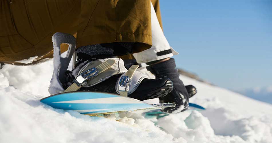 Strapping into snowboard at Caberfae Peaks.