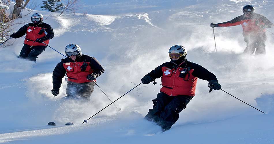 Ski patrol riding on the mountain trails.