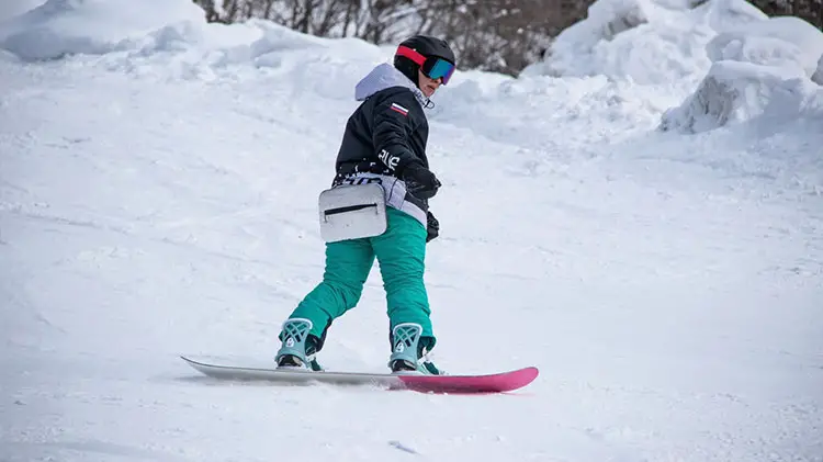 Snowboarder on slopes riding downhill