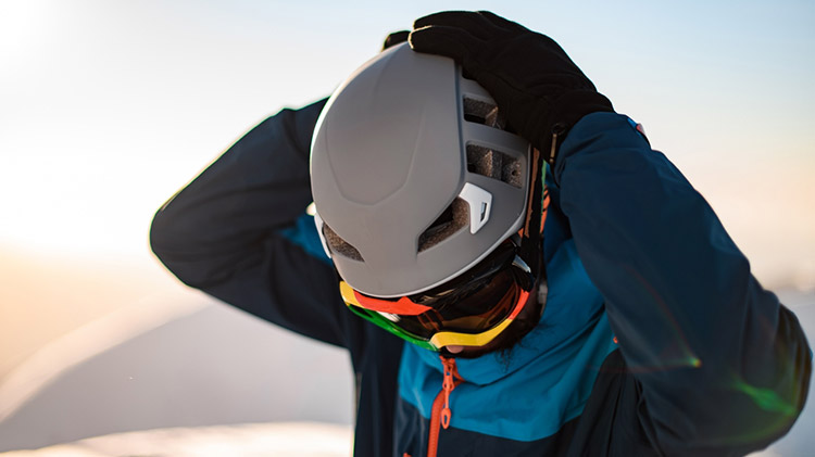 Setting up music on the slopes in ski helmet.